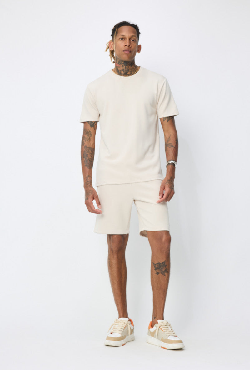 Ensemble basic beige NO LIMIT composé d'un haut et d'un pantalon en tissu doux, porté par un mannequin.