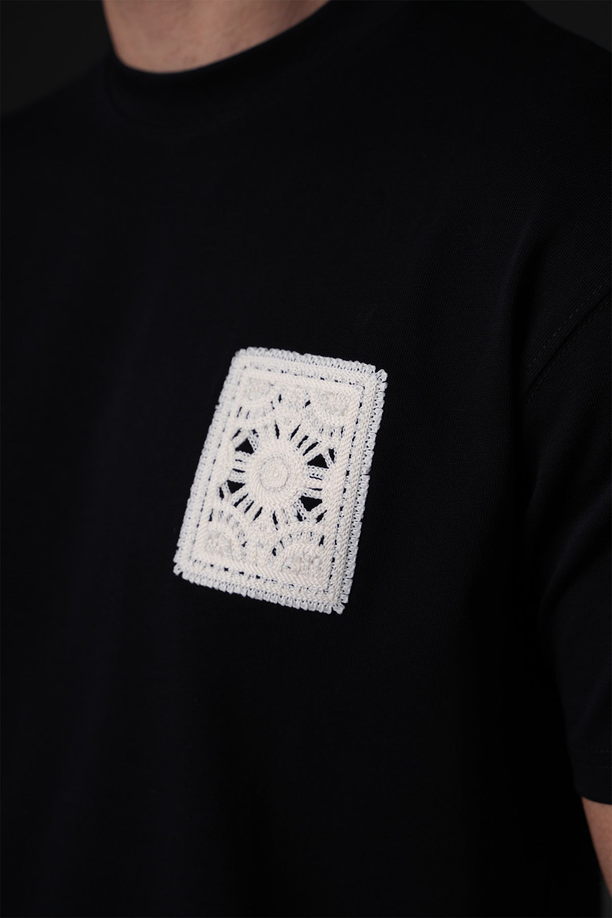 T-shirt carré brodé noir de la marque NO LIMIT, vue de face avec détails de la broderie visible.