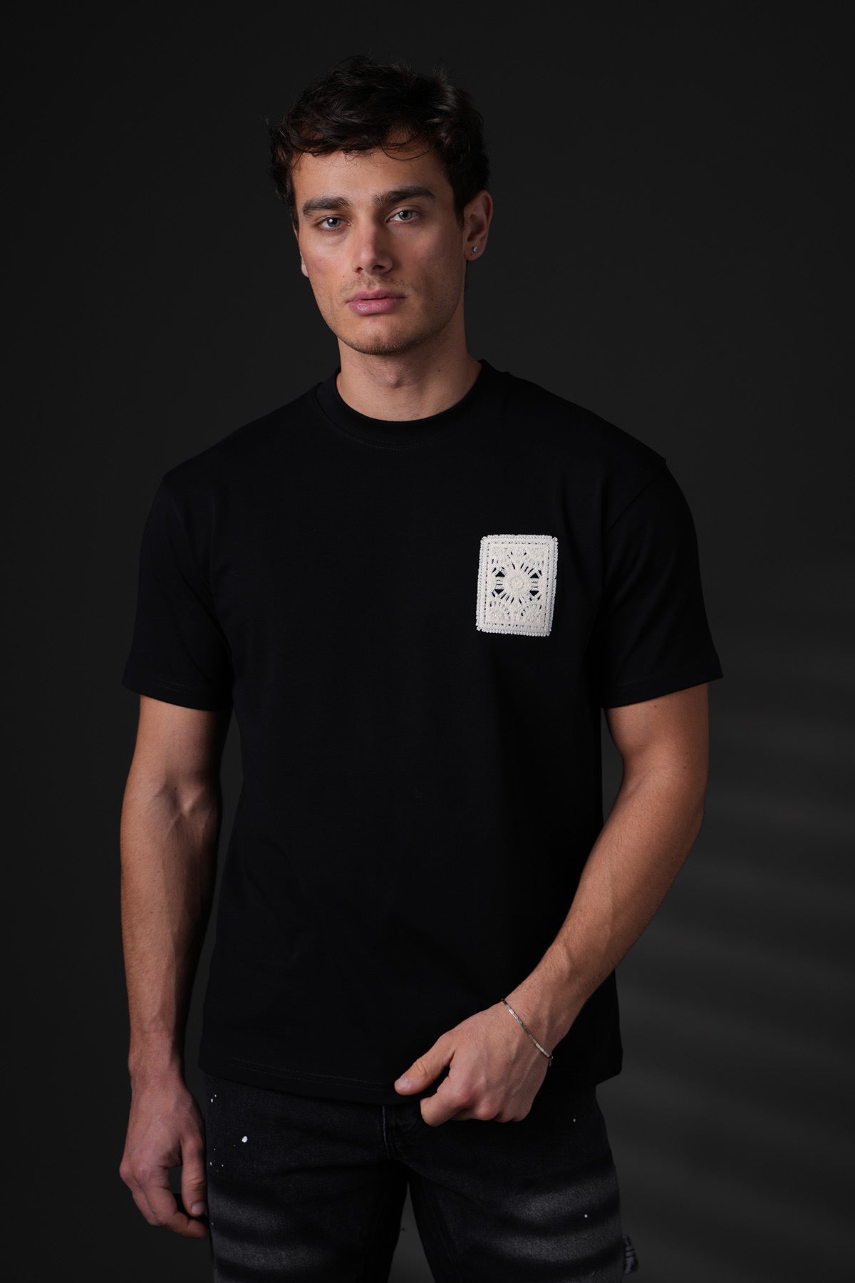 T-shirt noir brodé avec carré de la marque NO LIMIT, vue de face, détails du design et de la texture du tissu.