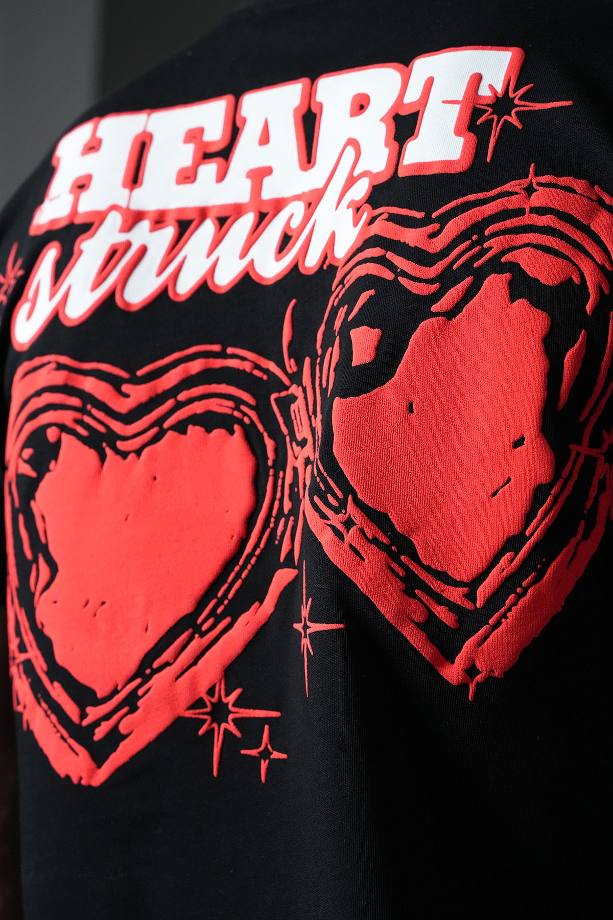 T-shirt noir avec un cœur imprimé, fabriqué par NO LIMIT, affiché sur un fond neutre.
