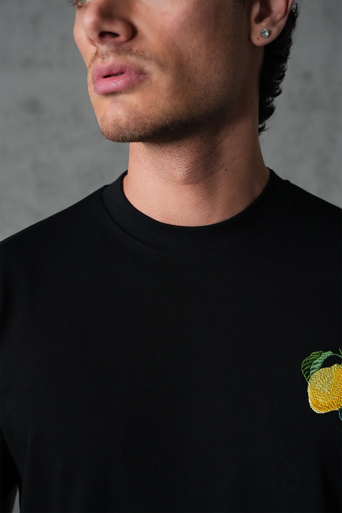 T-shirt noir avec motif citron de la marque NO LIMIT, vue en gros plan montrant le tissu et le design.