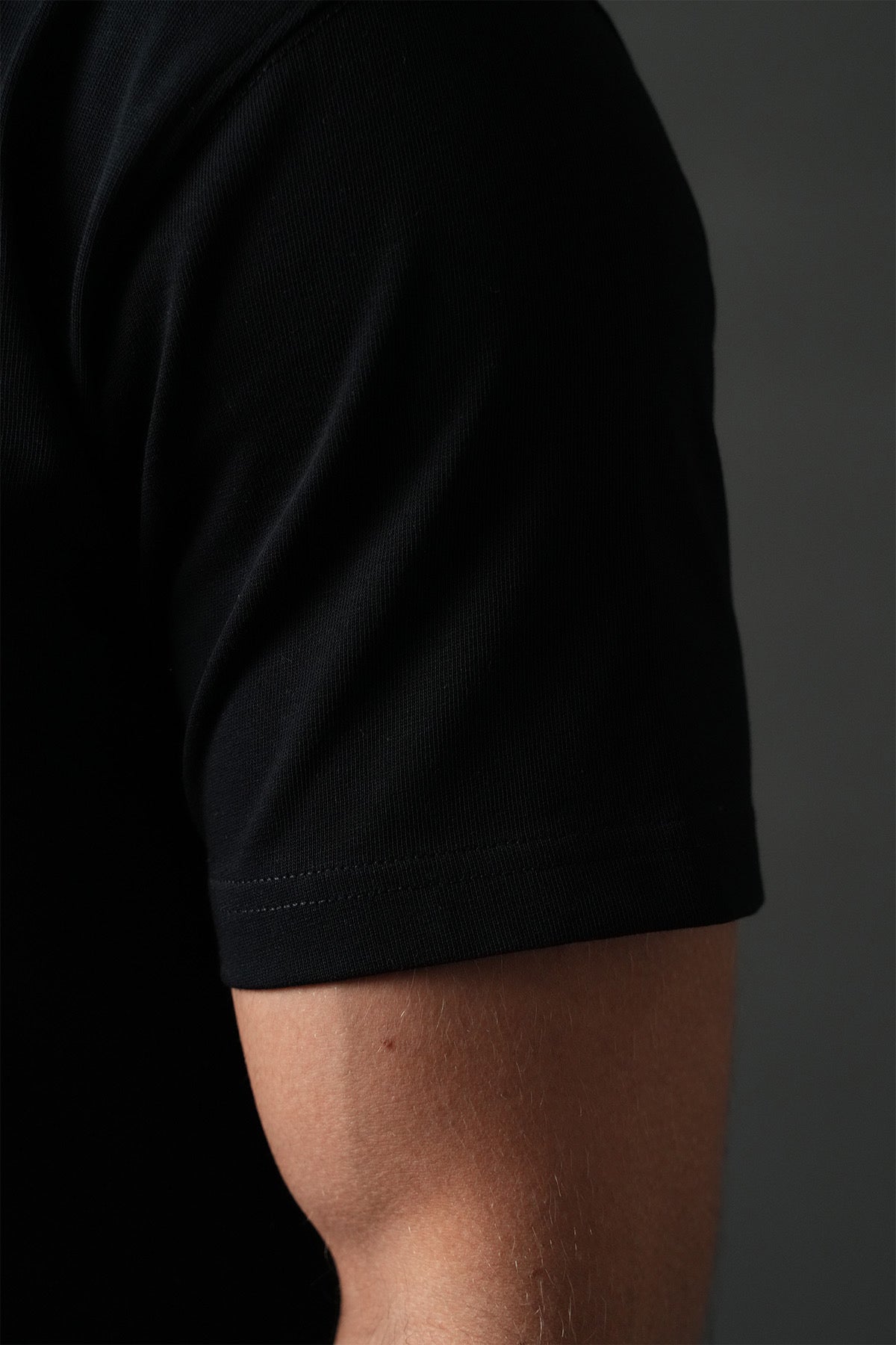 T-shirt tennis noir NO LIMIT, en coton, porté par un mannequin, affichant un design simple et élégant pour le sport.