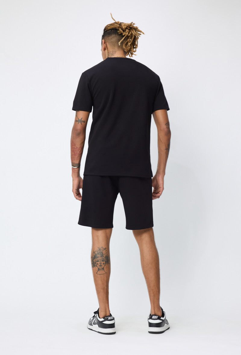 Ensemble basic noir de la marque NO LIMIT, composé d'un haut et d'un pantalon en tissu doux, porté par un mannequin.