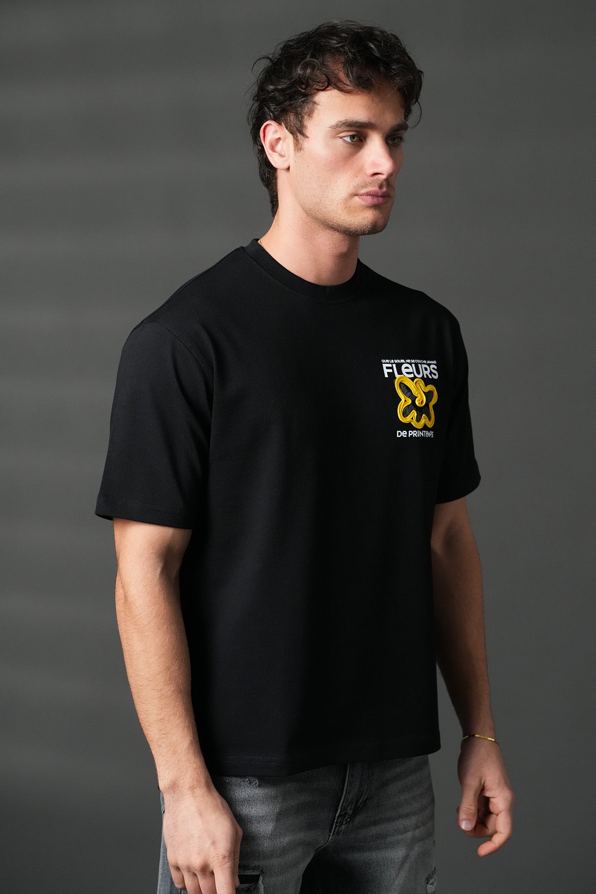 T-shirt noir avec motifs floraux de la marque NO LIMIT, vue de face avec détails des fleurs colorées.