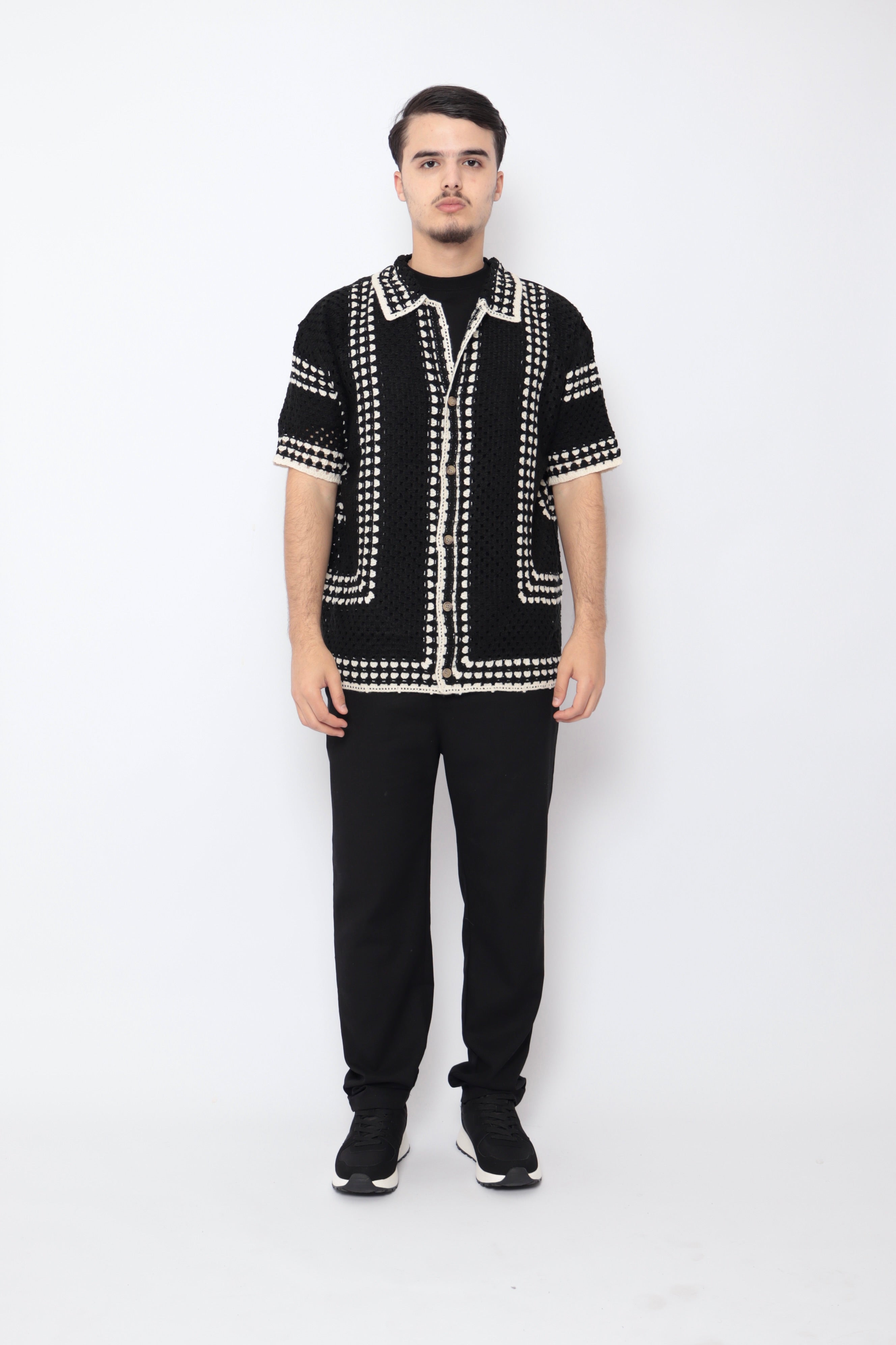 Chemise ajourée noire de la marque NO LIMIT, tissu léger avec motif carré, portée pour un style élégant et moderne.