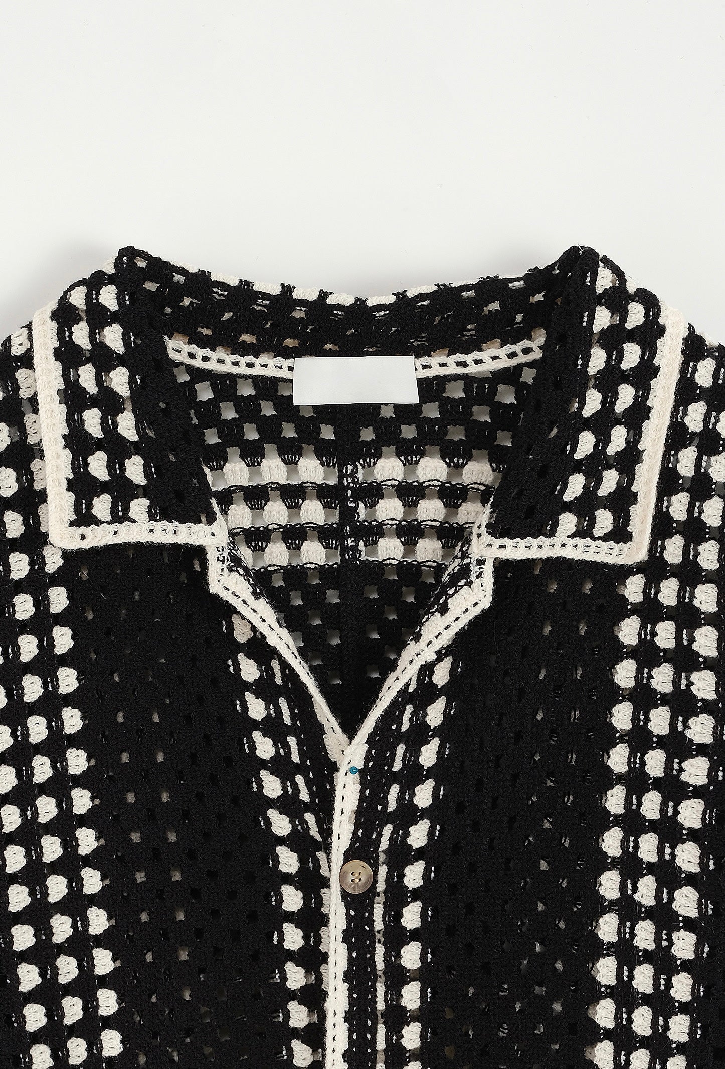 Chemise ajourée noire de la marque NO LIMIT, détail en carré, vue rapprochée sur le tissu translucide et les motifs en dentelle.
