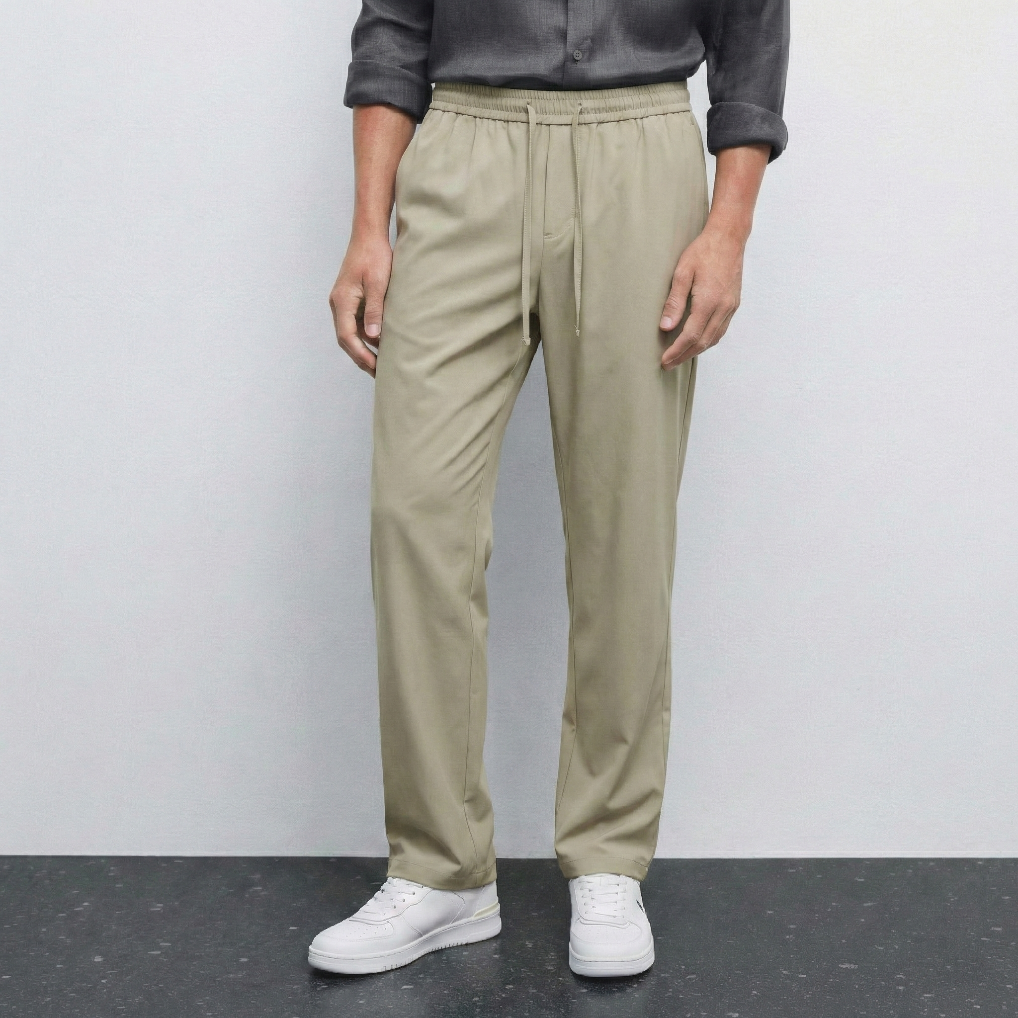 Pantalon beige NO LIMIT pour homme, coupe classique, tissu léger, porté avec une chemise blanche.