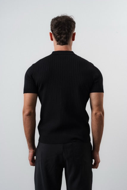 Polo noir à manches courtes NO LIMIT, coupe ajustée, porté sur mannequin, tissu lisse et élégant.