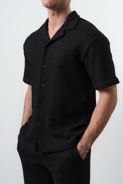 Ensemble maille gauffrée noir de la marque NO LIMIT, vêtement élégant en tissu texturé visible dans l'image.